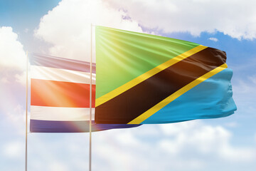 Sunny blue sky and flags of tanzania and costa rica