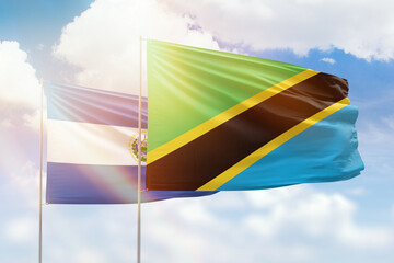 Sunny blue sky and flags of tanzania and el salvador