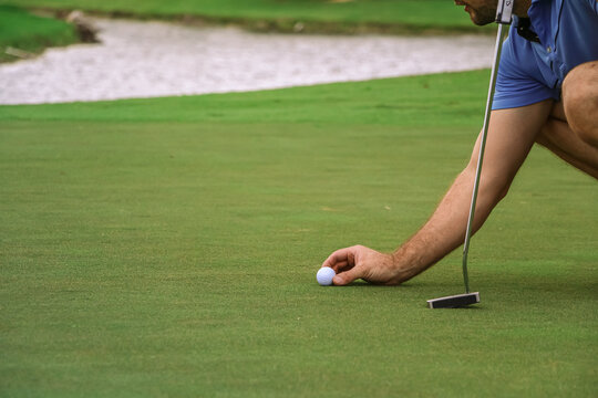 a golfer lining up is golf ball to putt