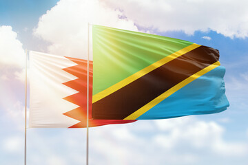 Sunny blue sky and flags of tanzania and bahrain