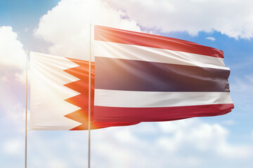 Sunny blue sky and flags of thailand and bahrain