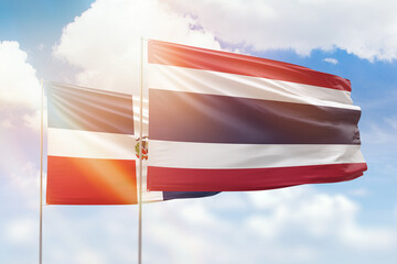 Sunny blue sky and flags of thailand and dominican republic