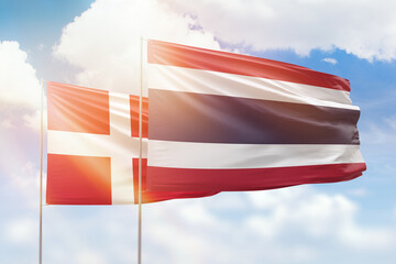 Sunny blue sky and flags of thailand and denmark