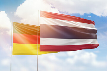 Sunny blue sky and flags of thailand and germany