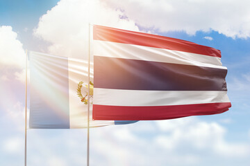 Sunny blue sky and flags of thailand and guatemala