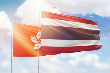 Sunny blue sky and flags of thailand and hong kong