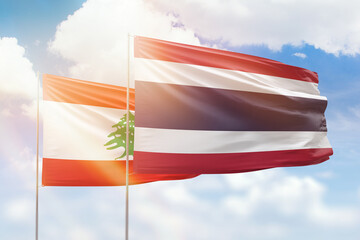 Sunny blue sky and flags of thailand and lebanon