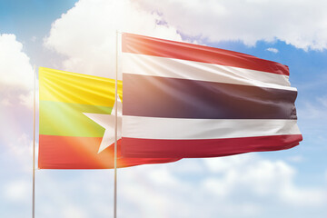 Sunny blue sky and flags of thailand and myanmar