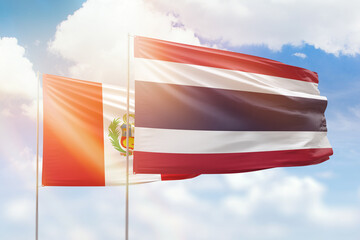 Sunny blue sky and flags of thailand and peru