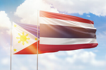 Sunny blue sky and flags of thailand and philippines