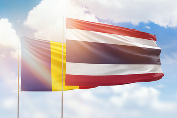Sunny blue sky and flags of thailand and romania