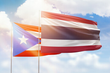 Sunny blue sky and flags of thailand and puerto rico
