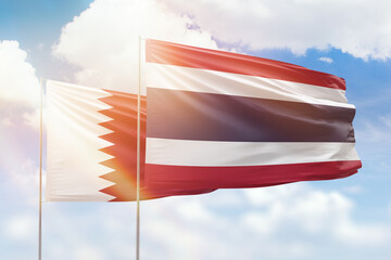Sunny blue sky and flags of thailand and qatar