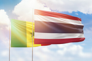 Sunny blue sky and flags of thailand and senegal