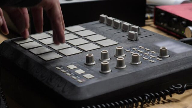 Beat maker making music on drum machine. Closeup on hands