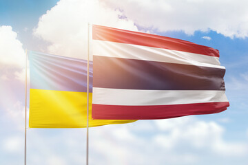 Sunny blue sky and flags of thailand and ukraine