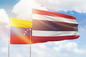 Sunny blue sky and flags of thailand and venezuela