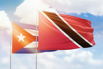 Sunny blue sky and flags of trinidad and tobago and cuba