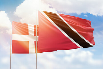 Sunny blue sky and flags of trinidad and tobago and denmark