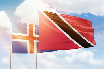 Sunny blue sky and flags of trinidad and tobago and iceland