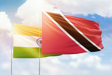 Sunny blue sky and flags of trinidad and tobago and india