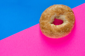 Macro of Sesame Seeds Bagel on Pink and Blue Background