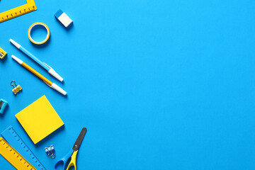 Flat lay blue and yellow office stationery on blue background. Back to school concept. School supplies top view.