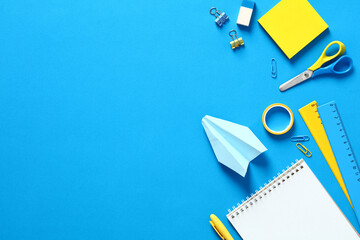 Blue and yellow school supplies and stationery on blue table top view. Back to school banner design.