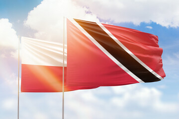 Sunny blue sky and flags of trinidad and tobago and poland