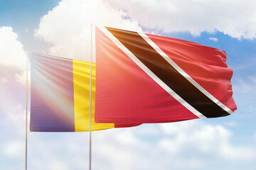 Sunny blue sky and flags of trinidad and tobago and romania