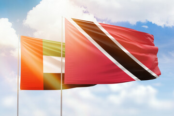 Sunny blue sky and flags of trinidad and tobago and uae