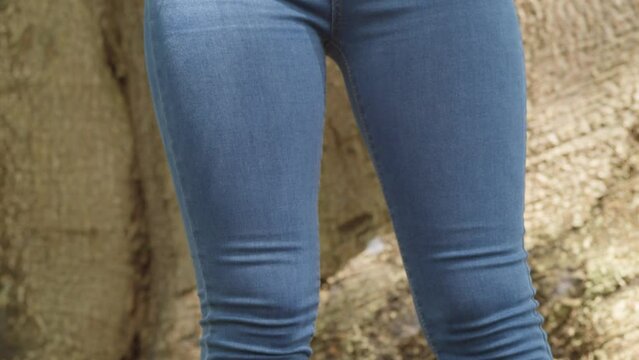 Descending camera movement of a young girl in a jeans to reveal her white sneakers