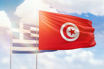 Sunny blue sky and flags of tunisia and greece