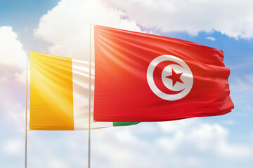 Sunny blue sky and flags of tunisia and ivory coast