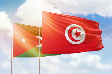 Sunny blue sky and flags of tunisia and jordan