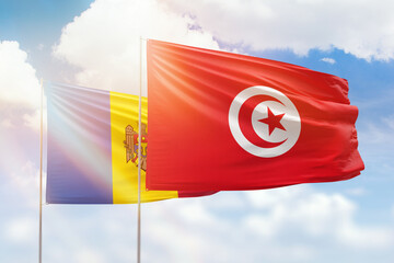 Sunny blue sky and flags of tunisia and moldova