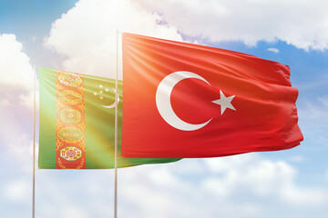 Sunny blue sky and flags of turkey and turkmenistan