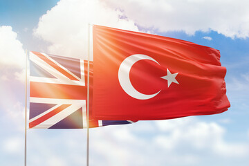 Sunny blue sky and flags of turkey and united kingdom