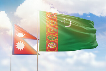 Sunny blue sky and flags of turkmenistan and nepal