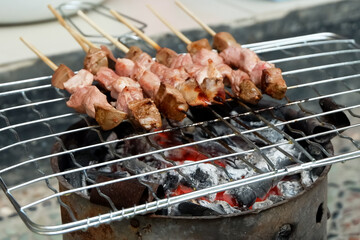 Sate Sapi or meat satay, the process of making satay on a charcoal grill.
