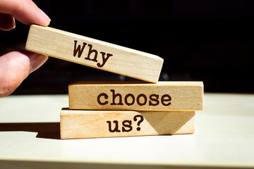 Businessman puts wooden blocks with the words Why Choose Us Question.