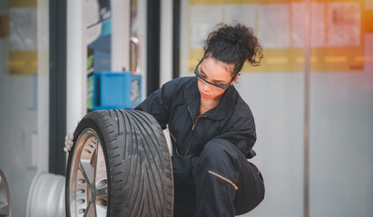Fototapeta na wymiar Car mechanics under checking quality of car wheel to repair or change new for customer in garage.