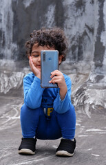 two year old baby girl taking photos in smart phone