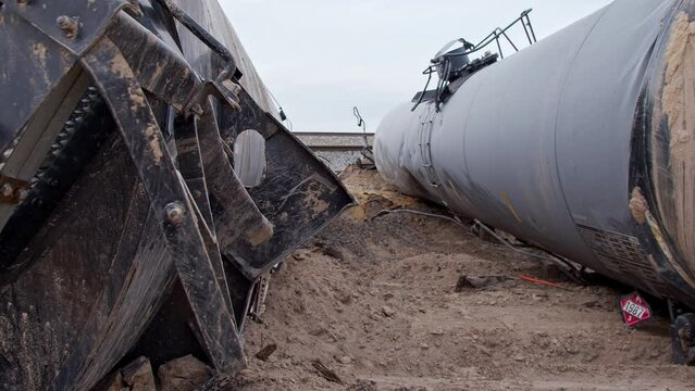 Panning the wreckage of train car tankers carrying flammable loads after derailing the tracks in the Utah desert.