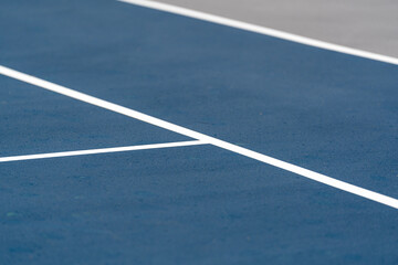 Fototapeta premium New blue tennis court with white lines and gray out of bounds 