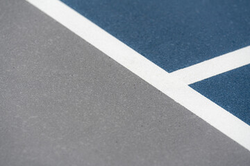 Fototapeta premium Blue tennis court with white lines and gray out of bounds 