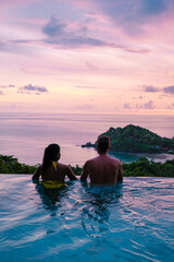a young couple of men and women at a swimming pool during a vacation on a tropical island. man and...