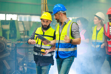 Unity and teamwork concept. caucasian male engineer factory manager worker and hispanic latin mechanic team walking together in factory workshop