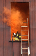 firefighters with a respirator and oxygen bottle nothing from a window completely vaulted with...