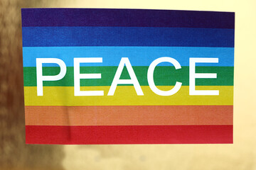 multicolored peace flag with text on golden background